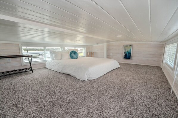 Un dormitorio con una cama grande, un escritorio y un cuadro en la pared.
