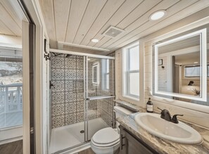 A bathroom with a shower, toilet, and sink.