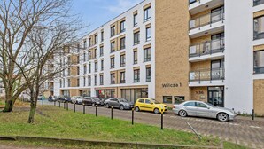 Monikerroksinen rakennus, jossa on tiiliverhous ja useita parvekkeita.