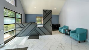A modern interior with a reception desk, seating area, and large windows. - Deluxe Studio at Extended Stay Cary 3 (Cary)