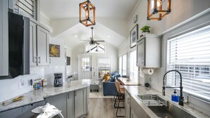 A modern kitchen with a central island, built-in appliances, and pendant lighting. - Rinconcito Magico - 200 (Fredericksburg)