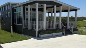 A modern house with a covered porch, large windows, and a concrete driveway.