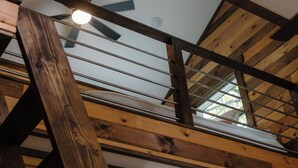 A wooden staircase with a ceiling fan and skylight.