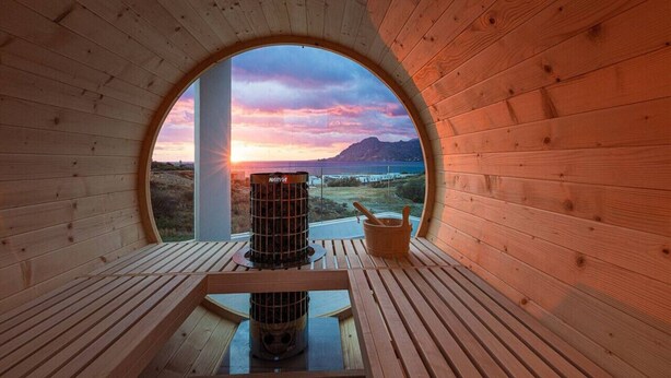 A wooden interior with a circular window offering a view of a sunset over a landscape. - Villa w 2 pools, BBQ, Sauna,250m to Plakias Beach (Μυρθιανος Πλακιάς)