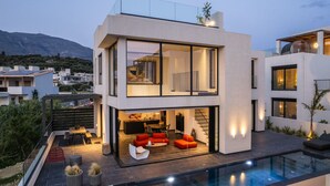 A modern two-story house with a swimming pool, outdoor seating, and a view of the surrounding area. - Villa w 2 pools, BBQ, Sauna,250m to Plakias Beach (Μυρθιανος Πλακιάς)