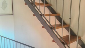Una escalera con escalones de madera y barandillas de metal.