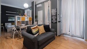 Un salon moderne comprenant un canapé, une table à manger et un coin cuisine.