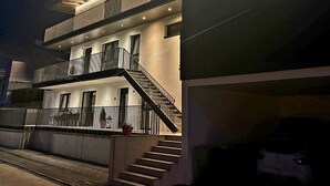 A modern multi-story building with a prominent staircase and a covered balcony area. - BERGLIEBE (Kaprun)