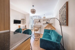 A modern living space with a kitchen area, a dining table with chairs, a sofa, and a large floor lamp. - BeBarceloner Sant Andreu Apartments (Barcelona)