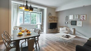 Een eetruimte met een houten tafel en stoelen, een televisie en een open haard.