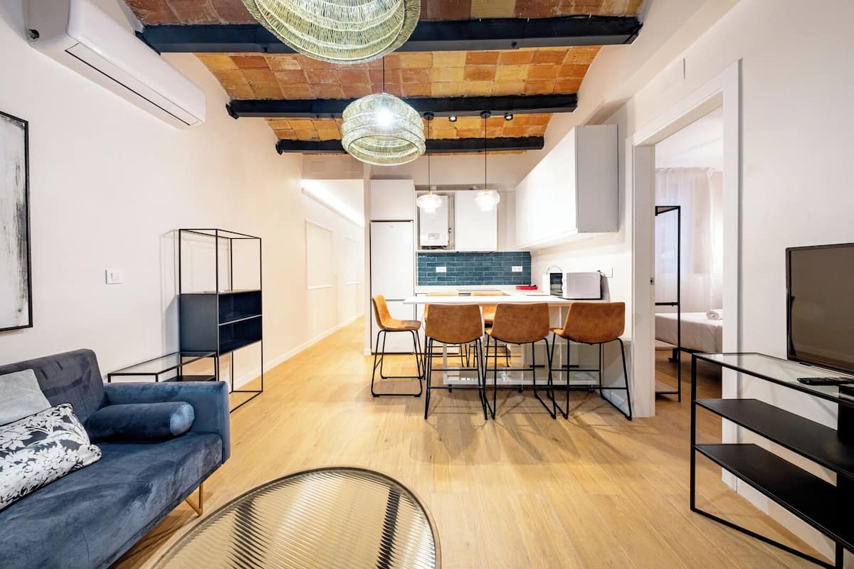 A modern apartment with a dining area, kitchen, and living space.