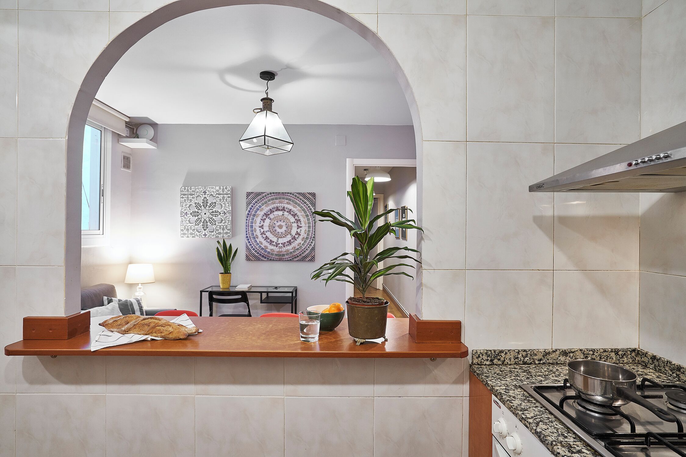 Una cocina con encimera, estufa y lámpara colgante.