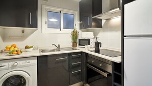 Une cuisine moderne équipée d’un lave-linge, d’un four à micro-ondes et d’un réfrigérateur.