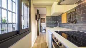 Une cuisine étroite avec une fenêtre, un évier et une cuisinière.
