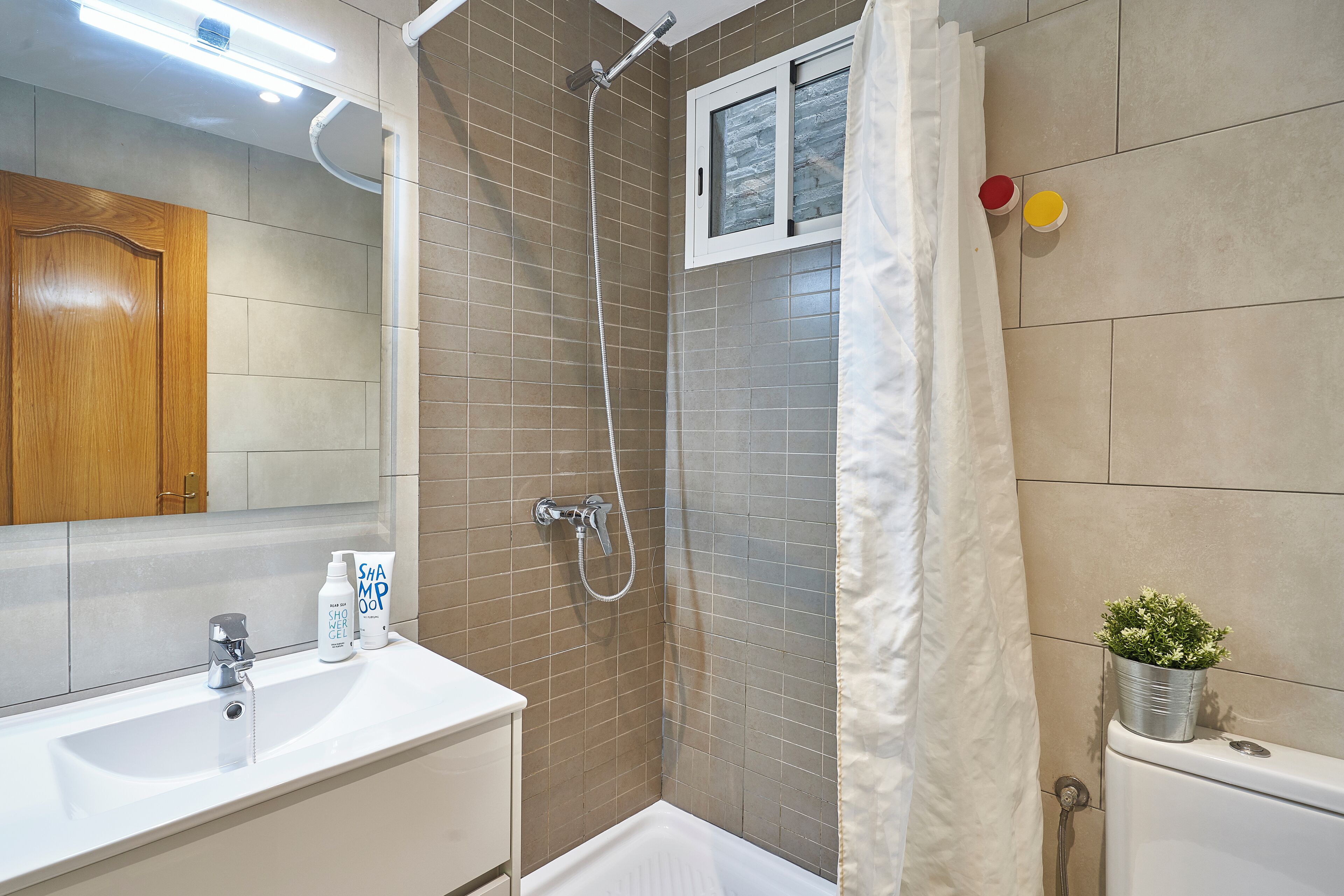 A bathroom with a shower, a sink, and a toilet.