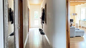 A hallway with wooden beams, tiled flooring, and a mirror on the left. - Apartment Sonnenlay OG (Brauneberg)