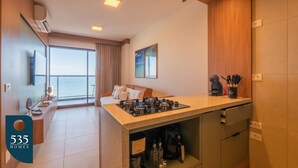 Eine moderne Küche mit Gasherd, einer Kaffeemaschine und Meerblick.