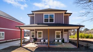 A two-story house with a covered patio area. - Modern 4BR Athens Retreat | Massage Chairs | Sleeps 9 | Near UGA & Downtown (Athens)