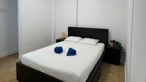 Un dormitorio moderno con estructura de cama negra, ropa de cama blanca y una lámpara de techo.