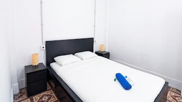 Une chambre moderne avec un grand lit, deux tables de chevet et des carreaux de sol à motifs.
