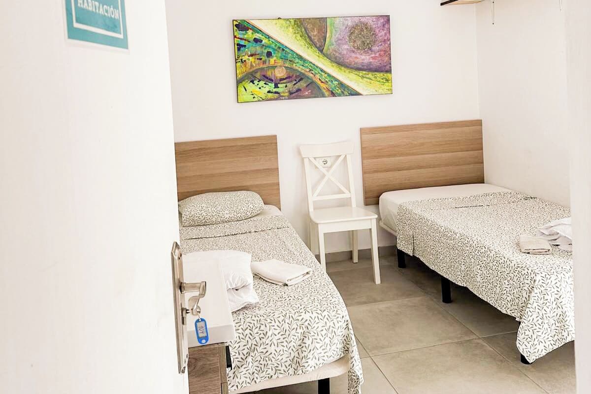A room with two beds, a ceiling fan, a painting, and a sign indicating Room 109.