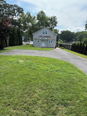 A two-story house with a front porch, a driveway, and a well-maintained lawn.