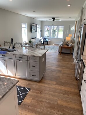 A spacious kitchen with a large island, wooden flooring, and modern appliances.