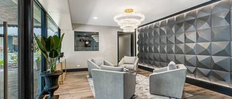 A modern interior with a seating area, a large window, and a geometric wall design.