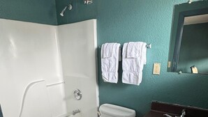 A bathroom with a bathtub, toilet, and sink. - Budget Motel (Orlando)