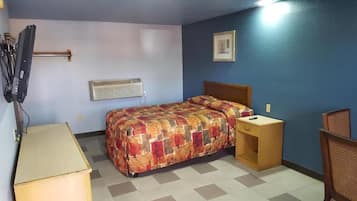 Une chambre à coucher comprenant un lit, une table de chevet, un téléviseur et un appareil de climatisation.