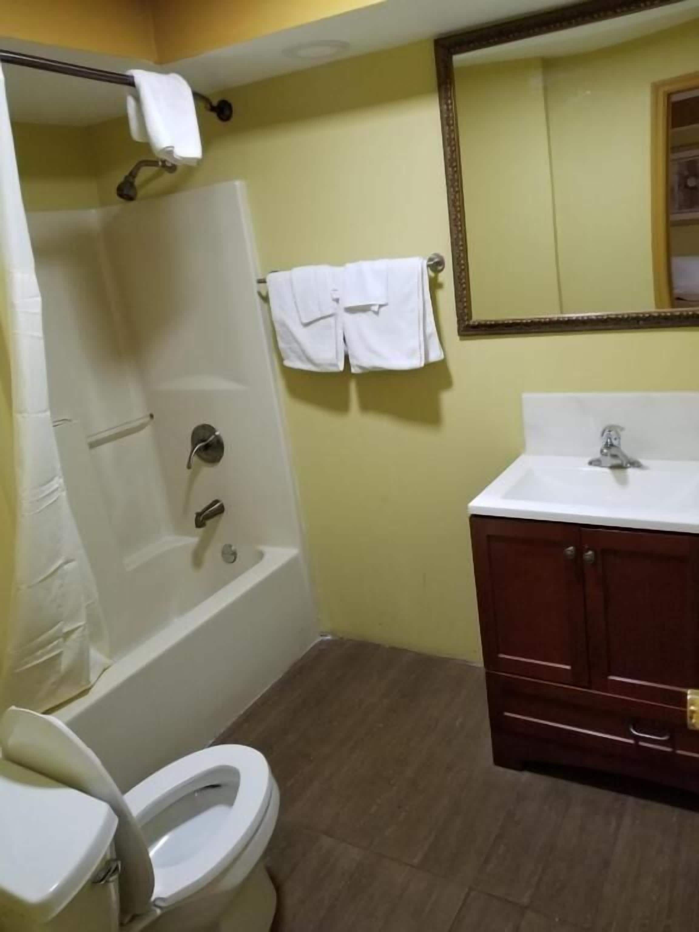 A bathroom with a bathtub, toilet, and sink.