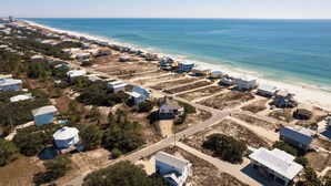 Luftaufnahme einer Küstenwohngegend mit Häusern, Straßen und einem Strand.