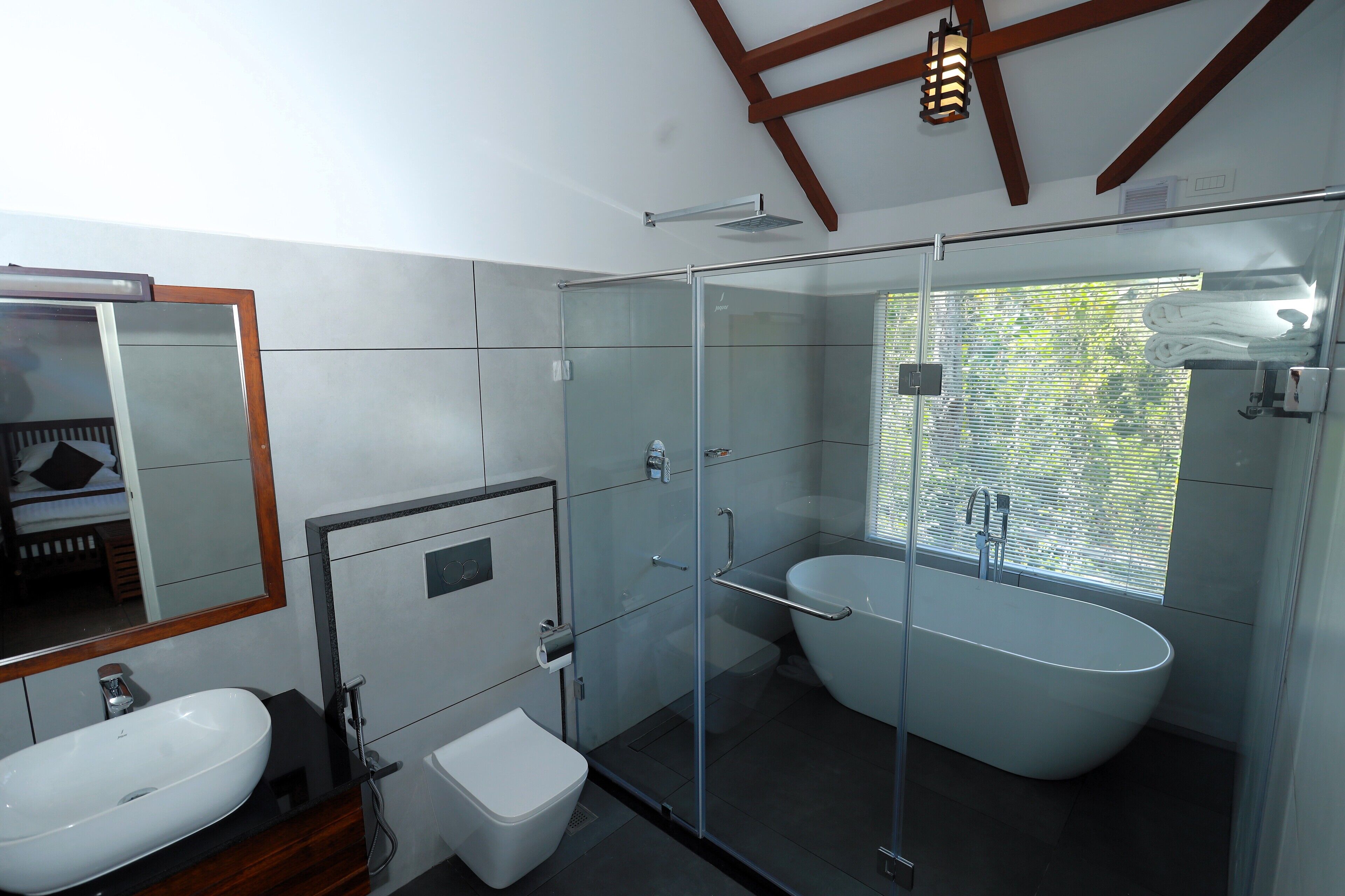A modern bathroom with a glass-enclosed shower, a freestanding bathtub, and a vanity with a sink.
