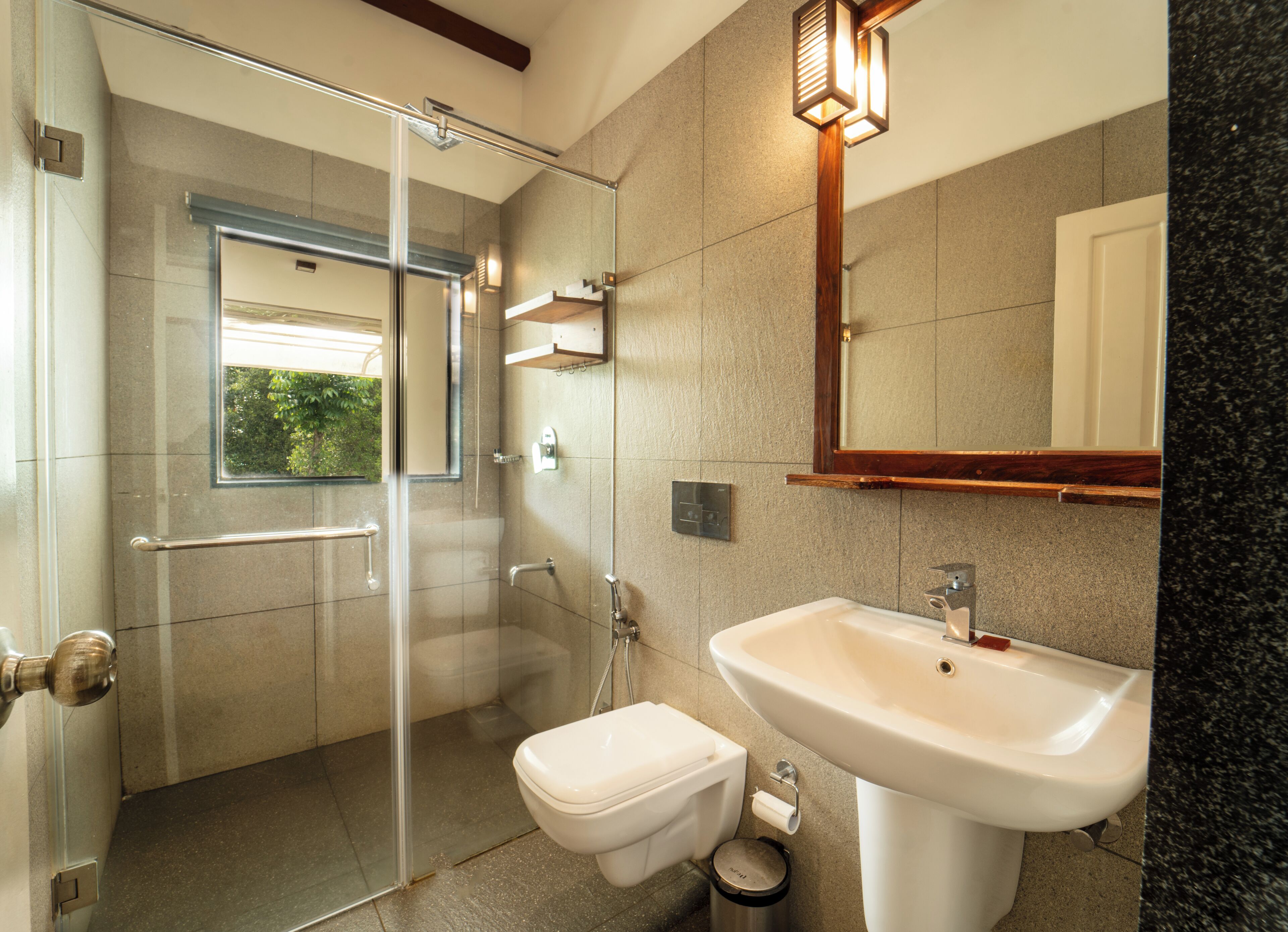 A modern bathroom with a glass-enclosed shower, a white sink, and a toilet.