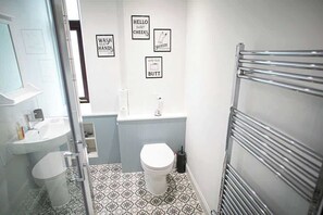 Ein Badezimmer mit Toilette, Waschbecken und Handtuchhalter.