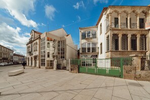A street with buildings, a green gate, and a clear sky.