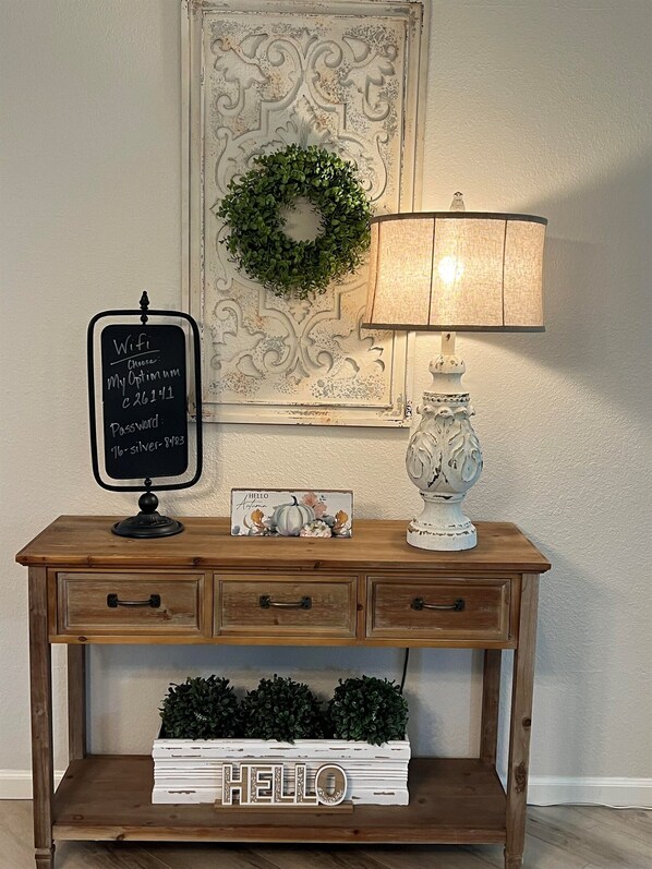 A wooden console table with a chalkboard sign, a decorative lamp, a vase, and a 'HELLO' sign. - "Fairway to Fun" 7 Night Discount~Walk-In End Unit~Indoor Pool~Trout~Pickleball (Branson)