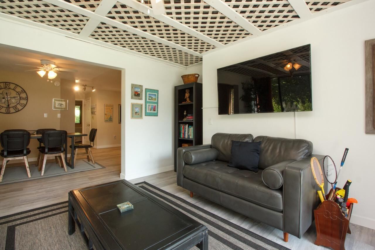A living room with a grey sofa, a coffee table, and a bookshelf.