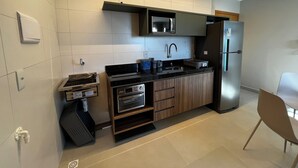 Eine moderne Küche mit eingebauter Mikrowelle, Backofen und Kühlschrank.