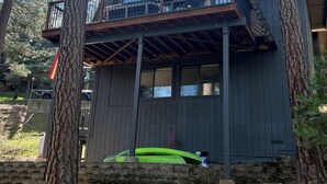 A modern cabin with a balcony, surrounded by tall trees. - Cozy 3-Level cabin in Groveland with WiFi, stunning views, deck and hot tub (Groveland)