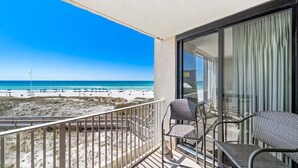 Un balcon avec vue sur une plage et l’océan.