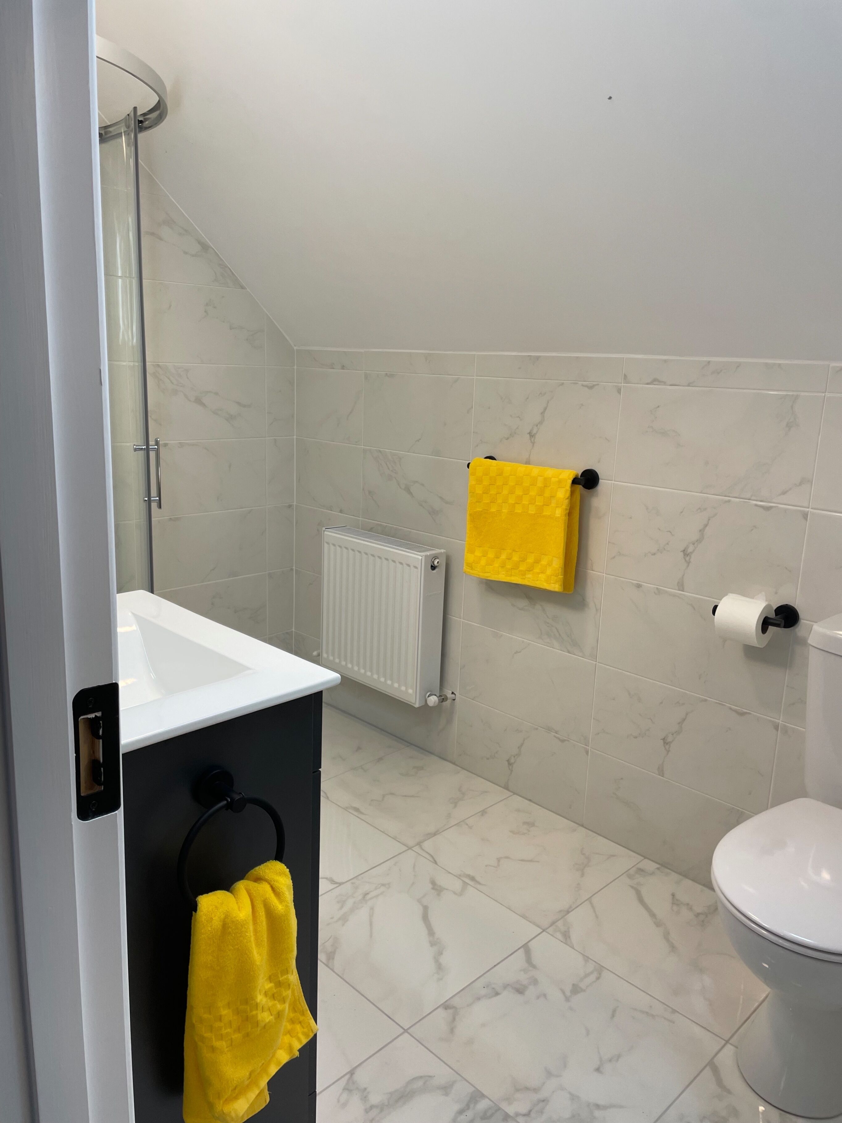A bathroom with a white sink, a toilet, and a shower area.