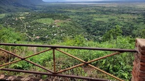 Vista panorâmica de um vale com casas dispersas e vegetação, vista de um ponto elevado.