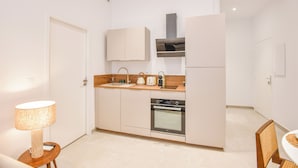 Eine kompakte Küche mit Backofen, Spüle und Mikrowelle.