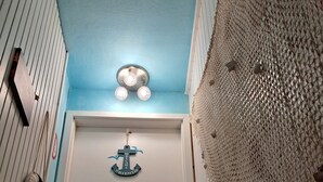 A hallway with a blue ceiling, a white door, and a textured wall.