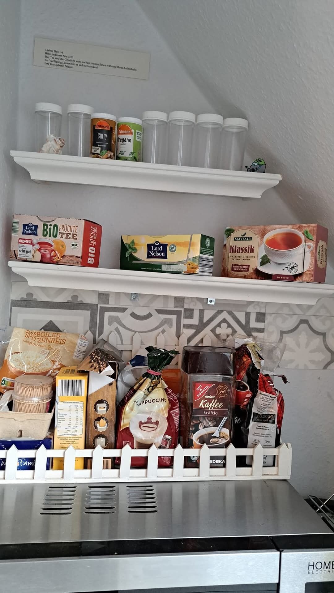 Een keuken met planken vol verschillende etenswaren en een koffieapparaat.