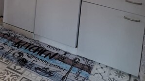 Una cucina con lavastoviglie Bosch, lavello e schienale decorato.