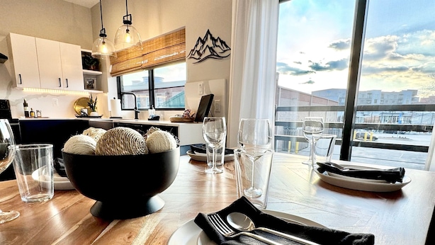 A modern kitchen with a dining area set for a meal.