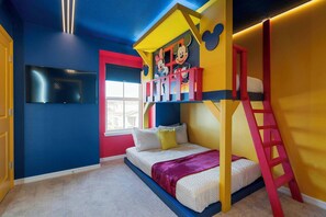 A brightly colored children's room with a bunk bed, a ladder, and a window.