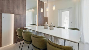 A modern dining room with a long table, green chairs, and pendant lights. - Stunning Pool Home just minutes from Disney 12 (Clermont)